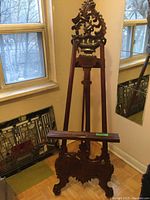 Front view of carved easel stand showing full height and carved top