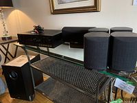 Pioneer SX-1300 receiver, subwoofer, center speaker and four surround speakers arranged on metal and glass shelves