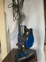 Shark Rocket upright vacuum cleaner standing on a surface with power cord wrapped around handle.