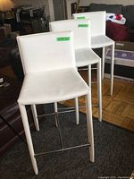 Front view of three stools lined up on rug