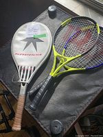 Photo showing three tennis rackets, one with a white Kneissl cover and two rackets with different colored frames.