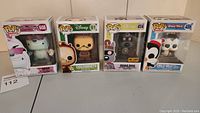Four Funko Pop vinyl figures in original boxes displayed side by side: Bear Teen Titans Go, Cogsworth Disney, Quail Dog Hot Topic Exclusive, and Chilly Willy with pancakes.