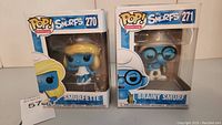 Two Funko Pop! vinyl Smurfs figures in original boxes, Smurfette #270 on left, Brainy Smurf #271 on right