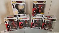 Full set of seven Funko Pop! Deadpool and Cable vinyl bobble-head figures displayed in original boxes showing front and side views for each.