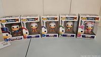 Front view showing all five boxed Funko Pop! Disney figures in a row: Scrooge McDuck (306), Huey (307), Dewey (308), Louie (309), Webby (310).