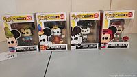 Front view of the four boxed Funko Pop! figures from the Disney Mickey The True Original 90 Years series displayed side by side: Brave Little Tailor (#429), Band Concert Mickey (#430), Plane Crazy (#431), and Gamer Mickey (#471, EB Exclusive).