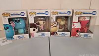 Four Funko Pop vinyl figures in original boxes arranged side by side: Sulley, Boo, Roz, Chef.