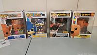 Photo shows four boxed Funko Pop! Games vinyl figures: Vulpix #580, Sonic with Emerald #284, Crash Bandicoot Biker Outfit #275 Hot Topic Exclusive, Q*bert #169.