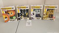 Photo showing the four Funko Pop! Cuphead games vinyl figures in boxes: Cagney Carnation #331, The Devil #312, King Dice #313, and King Dice #313 Limited Edition gold variant.