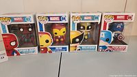 Photo showing full set of four boxed Funko Pop! Marvel figures: Spider-Man #03, Iron Man #04, Wolverine #05, Captain America #06, in upright position.