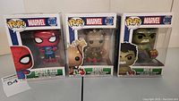 Front view of all three Funko Pop Marvel figures in boxes - Spider-Man #397, Groot #399, Hulk #398.