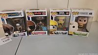 Four boxed Funko Pop! figures including Charlie Brown, The Beast from The Sandlot, Scott Howard from Teen Wolf, and Dr. Frank Poole from 2001: A Space Odyssey shown side by side.