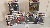 Photo showing six Funko Pop! boxes of Spider-Man: Into the Spider-Verse characters including Spider-Man Noir, Green Goblin, Prowler, Miles Morales, Peter Parker, and a second Spider-Man Noir.