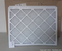 Single new 20x25x1 inch air filter standing upright in front of box, showing white pleated filtering material and diamond-shaped frame pattern.