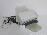 Full side view of the Kodak i1210 Plus scanner with power and USB cords, showing input and output trays extended.