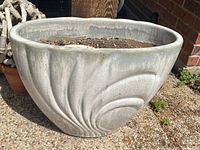 Side view of the large ceramic planter showing shell pattern in light gray and white hues.