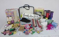 Overview of entire craft supply lot including ribbons, papers, felt, embellishments, and storage container