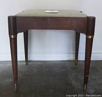 Front view of mid-century modern bench with tapered wood legs and brass metal accents. Upright position with upholstered seat.
