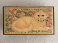 Top view showing detailed artistic lid featuring a Persian cat surrounded by floral designs.