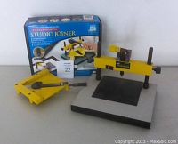 Logan Studio Joiner tool with base, adjustable arm, and clamp, showing components and box in background.