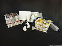 Overview of console, controllers, accessories and game stacks on black background