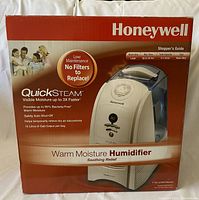 Original retail box of Honeywell Warm Mist Humidifier showing product image and features like 15 Liter capacity, QuickSteam, no filters needed, and safety auto shutoff.