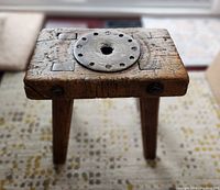 Front perspective showing top surface with metal plate and three legs visible