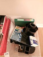 Top angled view of the lot showing black pencil holder organizer, black tray organizer, green 3-ring binder, QuickFolder, and boxed Epson cartridge and other office supplies