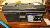 Closed black heavy duty plastic toolbox with handle, latch, and label showing 16" Strong N' Tuff Toolbox.