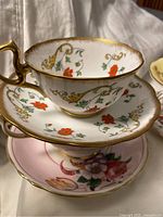 Stacked teacups and saucers showing Royal Albert set and pink floral set