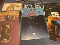 Group shot of eight vinyl albums laid out on bed showing all covers