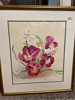 Full view of framed floral watercolor painting in gold frame