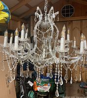 Full view of 12-light chandelier hanging with crystal drops