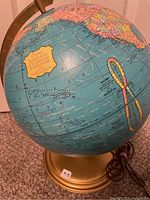 Full view of globe on base with power cord visible