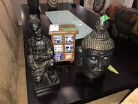 Overview photo showing all three items on a dark table: Buddha head, warrior figure, and wooden trinket box with ceramic drawers