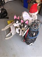 Photo showing full lot with two husky dog figures on sled, snowman figure, and wire-frame snowman decoration together on floor.