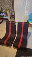 Front view of two black and red collapsible gaming chairs on floor, no visible damage.