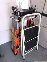 Photo of the Gorilla Ladder folded next to the white step ladder in a garage setting