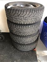 Four stacked Hankook snow tires mounted on steel rims, showing tread and wear.
