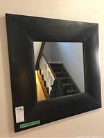 Front view of square wood framed mirror with rustic dark finish, showing slight wear on the frame.