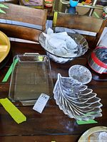 Wide shot showing all glass items on a wooden table, including the punch bowl with lid, leaf-shaped glass bowl, rectangular serving dish, and smaller bowls.