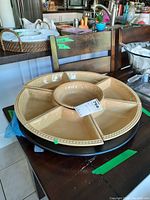 Sectional server shown from an angle, highlighting its size, shape, and beige color with beaded edge. Visible chip on the rim.