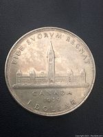 Reverse side of the 1939 Canadian silver dollar coin featuring the Canadian Parliament buildings and inscriptions.