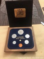 Open box showing six Canadian coins in blue display with 'Canada Official Officielle' text.
