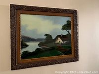 Full view of the framed vintage reverse painting showing the landscape and frame details.