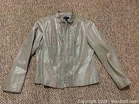 Front view of grey leather jacket showing design details and slight sleeve edge wear.