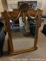 Full view of the large wall mirror showing the entire frame and reflective surface in a living room setting.