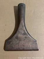 Top view of the brass chisel showing the overall shape and patina.