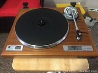 Front view of wooden plinth, platter, tonearm