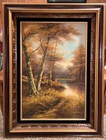 Full front view of the framed oil painting depicting fall trees by river, signed Cantrell.
